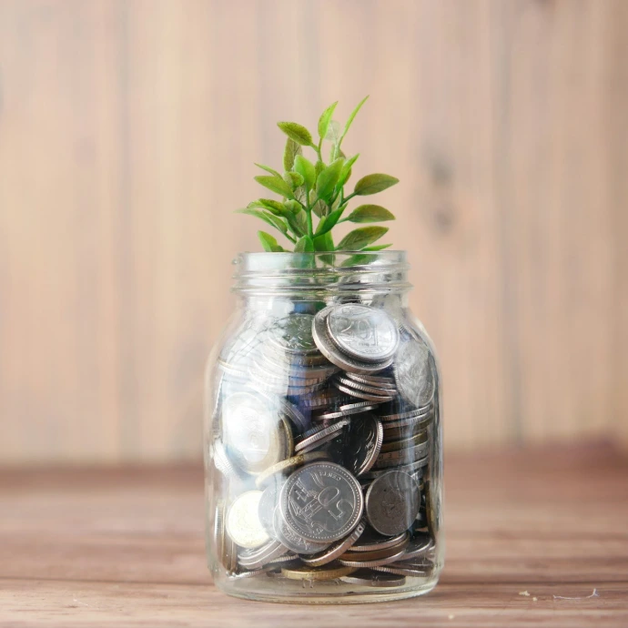 a glass jar filled with coins and a plant